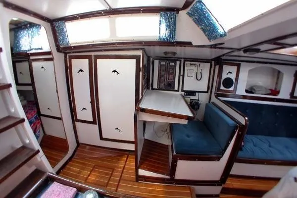 Slide: The Image of Interior of a 1993 Columbia Cutter sailboat with wood accents and blue seating. - 31