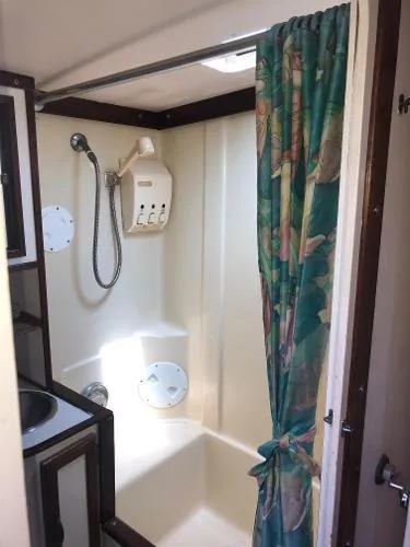 Slide: The Image of 1993 Columbia Cutter boat bathroom with shower, floral curtain, and compact design. - 32