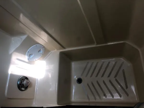 Slide: The Image of 1993 Columbia Cutter boat interior with beige shower area and drain. - 34