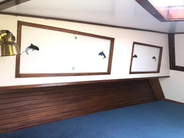 Slide: The Image of Interior of 1993 Columbia Cutter boat with wooden accents and dolphin decor. - 36