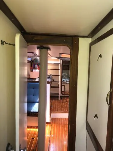 Slide: The Image of Interior of a 1993 Columbia Cutter sailboat, featuring wooden flooring and cozy seating. - 37
