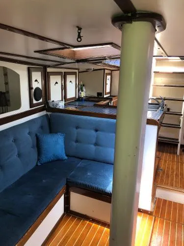 Slide: The Image of Interior of 1993 Columbia Cutter sailboat with blue cushioned seating and wooden flooring. - 40