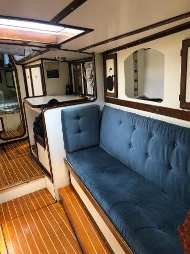 Slide: The Image of Interior of a 1993 Columbia Cutter sailboat with blue seating and wooden flooring. - 41
