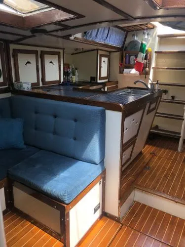 Slide: The Image of 1993 Columbia Cutter interior with wooden flooring, blue seating, and compact kitchen area. - 42