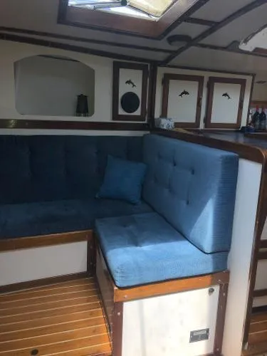 Slide: The Image of 1993 Columbia Cutter interior with blue cushioned seating and wooden accents. - 43