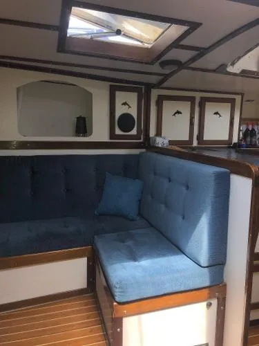 Slide: The Image of Interior of a 1993 Columbia Cutter sailboat with blue cushioned seating. - 45