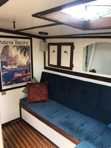 Slide: The Image of Interior of 1993 Columbia Cutter boat with blue seating and South Pacific poster. - 46