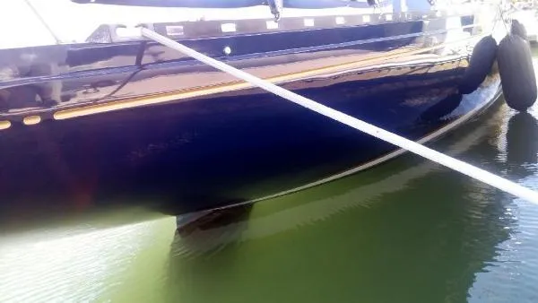 Slide: The Image of Sleek 1993 Columbia Cutter sailboat docked, reflecting on calm water. - 6