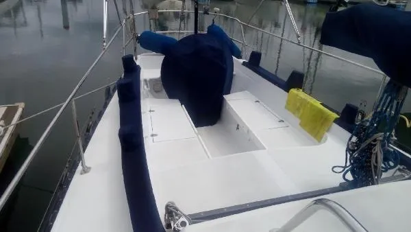 Slide: The Image of 1993 Columbia Cutter sailboat deck with blue covers and yellow towel in marina. - 9