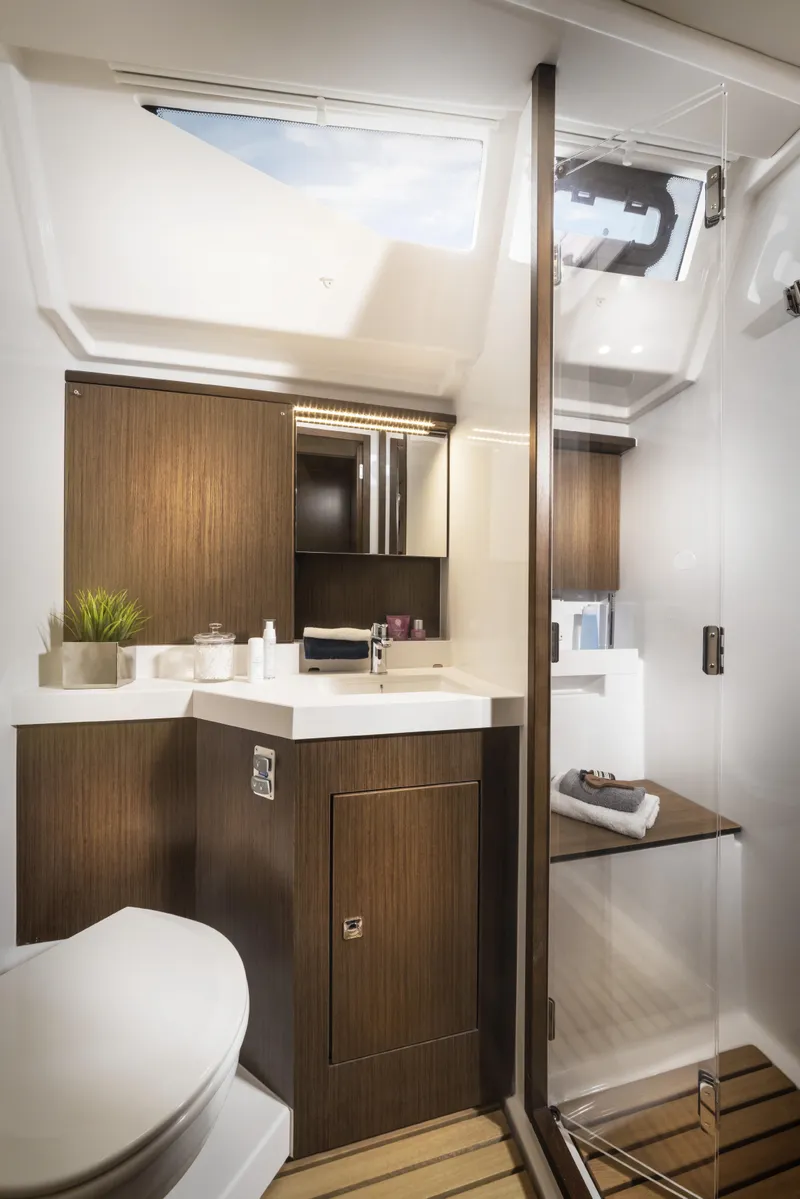 Slide: The Image of Modern bathroom interior in 2025 Bavaria C57 yacht, featuring sleek wood finishes and skylight. - 17
