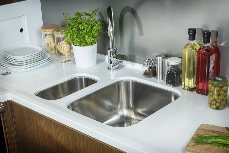 Slide: The Image of Modern kitchen sink area with herbs, oils, and dishes on a Bavaria C57 yacht, 2025 model. - 28
