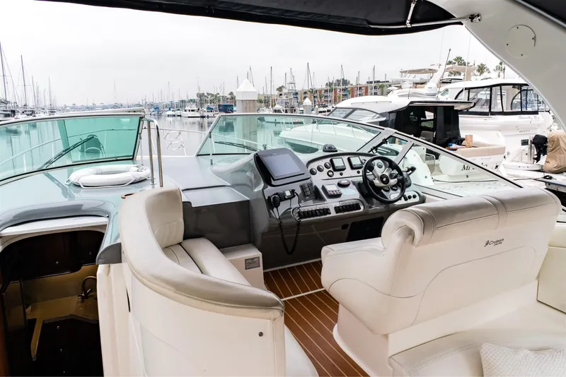 Slide: The Image of 2005 Cruisers Yachts 370 Express cockpit with luxurious seating and modern controls, docked at marina. - 14