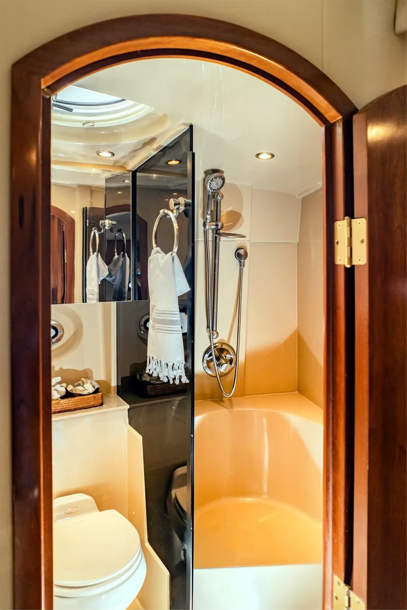 Slide: The Image of 2005 Cruisers Yachts 370 Express bathroom with shower, toilet, and elegant wood finish. - 6