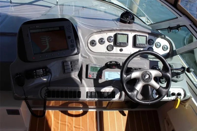 Slide: The Image of Helm of 2005 Cruisers Yachts 370 Express with navigation instruments and steering wheel. - 16