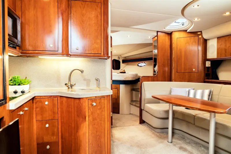 Slide: The Image of Luxurious 2005 Cruisers Yachts 370 Express interior with elegant wood cabinetry and cozy seating area. - 4