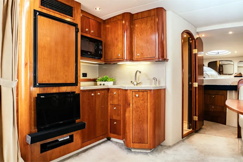 Slide: The Image of Luxurious 2005 Cruisers Yachts 370 Express interior with elegant wood cabinetry and modern amenities. - 5
