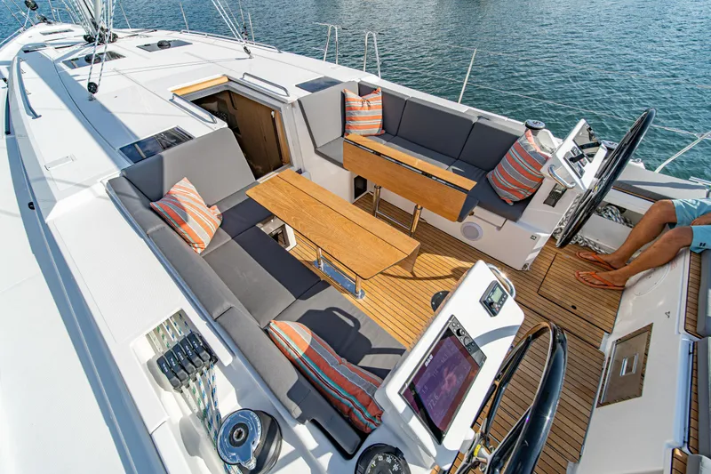 Slide: The Image of 2024 Bavaria C45 yacht cockpit with seating, wooden table, and nautical controls. - 14