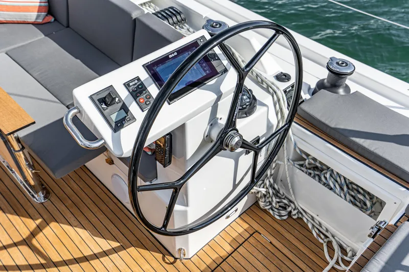 Slide: The Image of Steering wheel and controls of 2024 Bavaria C45 yacht on teak deck. - 32