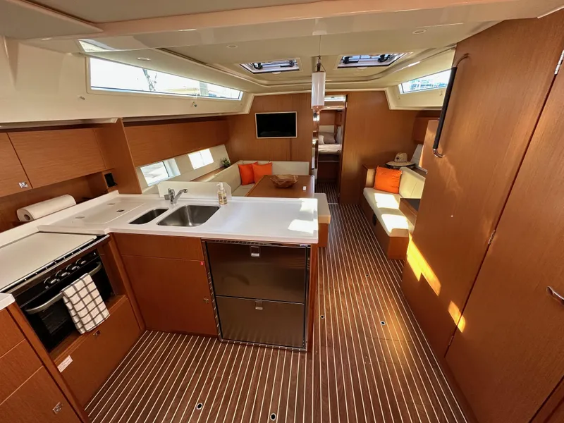 Slide: The Image of 2024 Bavaria C45 yacht interior with modern kitchen, seating area, and wooden flooring. - 34