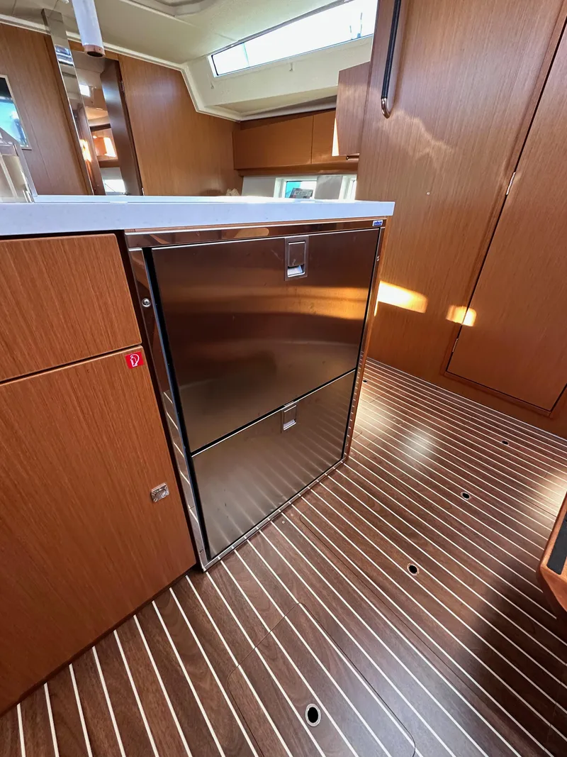 Slide: The Image of 2024 Bavaria C45 yacht interior with modern kitchen cabinetry and sleek wood flooring. - 39