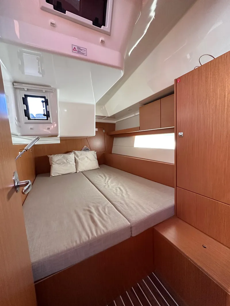 Slide: The Image of 2024 Bavaria C45 yacht cabin with cozy bed and wooden interior design. - 41