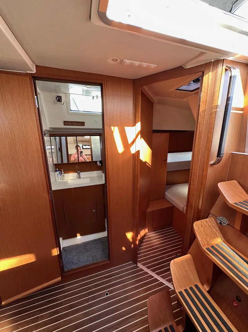 Slide: The Image of 2024 Bavaria C45 yacht interior with wooden finish, showing cabin and bathroom. - 45