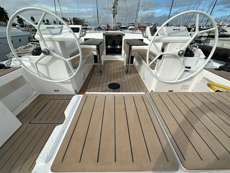 Slide: The Image of 2024 Bavaria C45 yacht cockpit with dual steering wheels and teak flooring. - 5