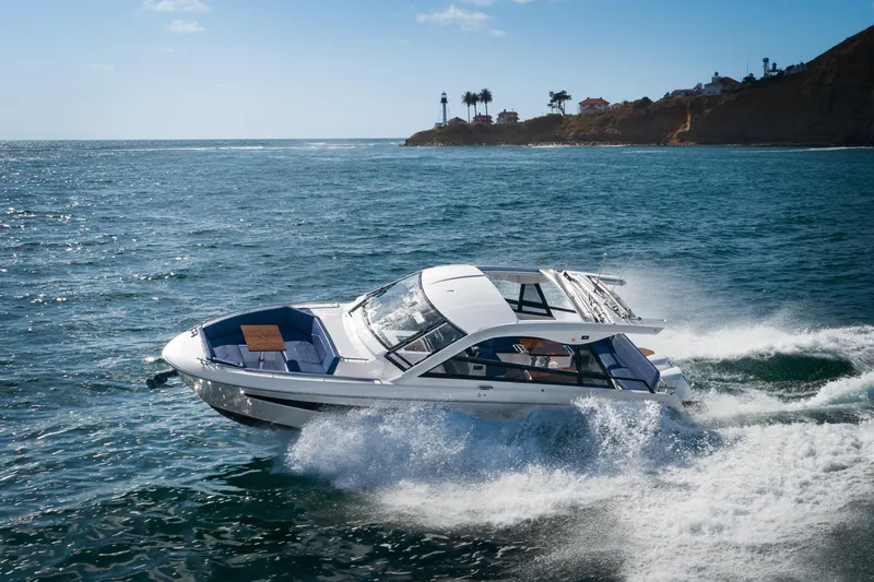 Slide: The Image of 2024 Bavaria Vida 33 yacht cruising on open water near a coastal lighthouse. - 16