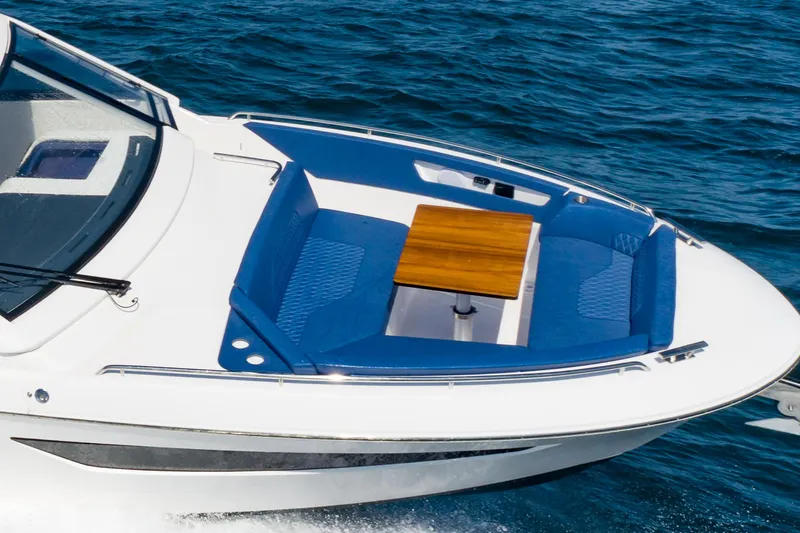 Slide: The Image of 2024 Bavaria Vida 33 boat with blue seating and wooden table on open water. - 27