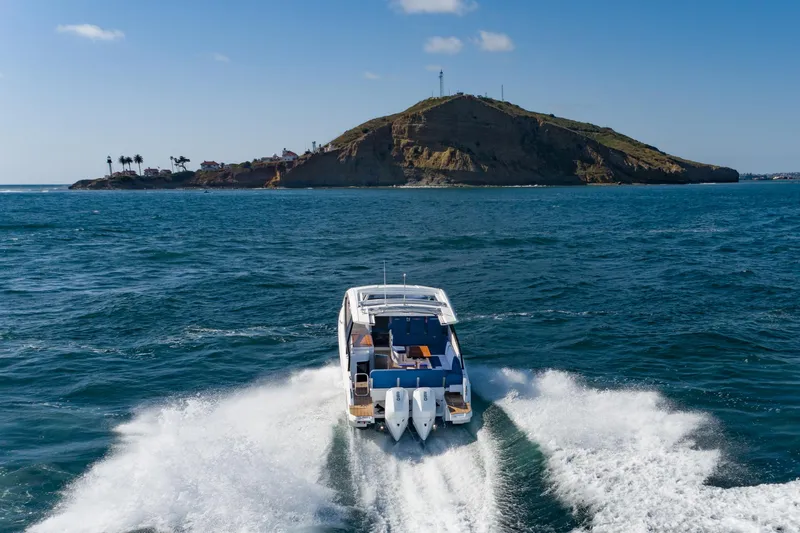 Slide: The Image of 2024 Bavaria Vida 33 boat cruising near an island under a clear blue sky. - 3