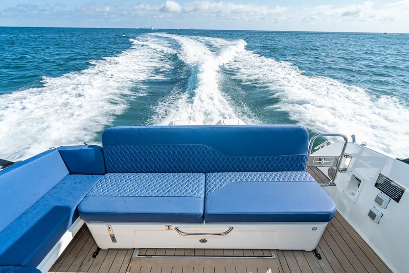 Slide: The Image of 2024 Bavaria Vida 33 boat with blue seating, cruising on open water. - 34