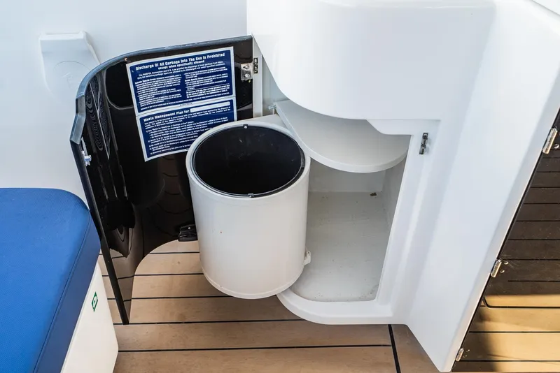 Slide: The Image of 2024 Bavaria Vida 33 yacht interior with open storage compartment and trash bin. - 40
