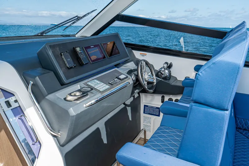 Slide: The Image of 2024 Bavaria Vida 33 yacht cockpit with modern navigation controls and blue seating. - 47