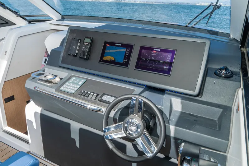 Slide: The Image of 2024 Bavaria Vida 33 yacht dashboard with modern navigation displays and steering wheel. - 48