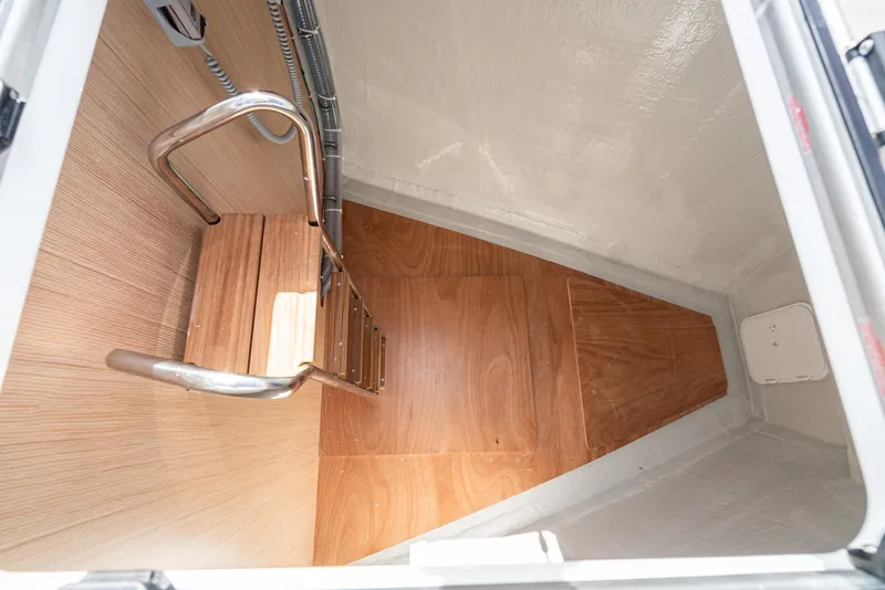 Slide: The Image of 2024 Bavaria C50 yacht interior with wooden flooring and metal ladder. - 18