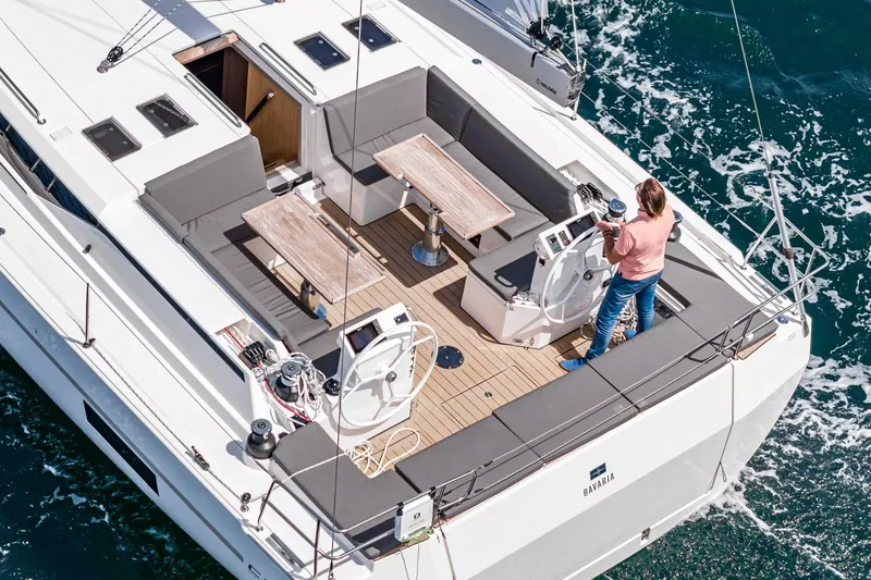 Slide: The Image of 2024 Bavaria C50 yacht with spacious deck, dual steering wheels, and modern seating on open water. - 26