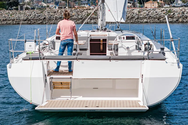 Slide: The Image of 2024 Bavaria C50 yacht, rear view, sailing on calm water with a person on deck. - 29