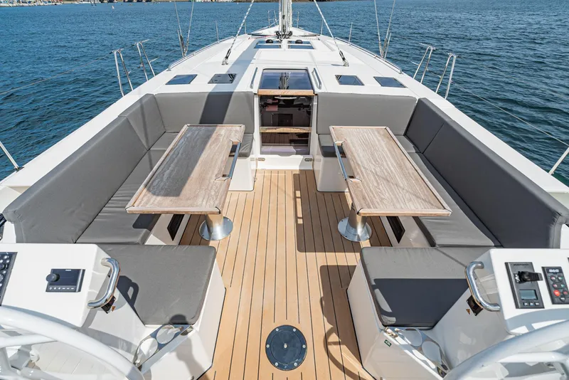 Slide: The Image of 2024 Bavaria C50 yacht deck with seating and tables, overlooking the ocean. - 30