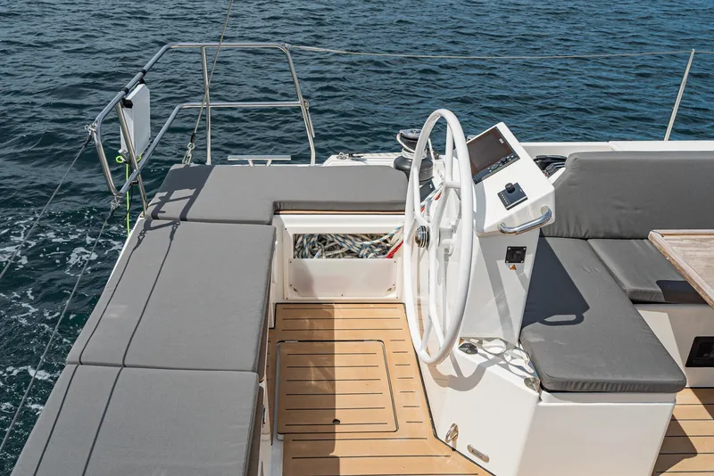 Slide: The Image of 2024 Bavaria C50 yacht cockpit with steering wheel and seating, overlooking the ocean. - 36