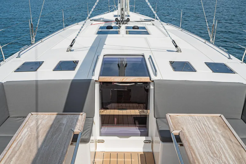 Slide: The Image of 2024 Bavaria C50 yacht deck with seating and tables, overlooking the ocean. - 43