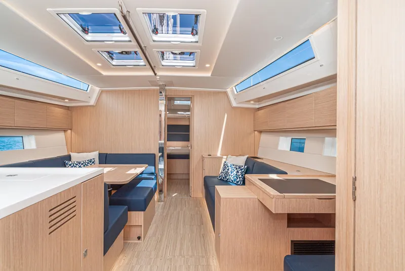 Slide: The Image of 2024 Bavaria C50 yacht interior with modern wood finish and blue seating. - 45