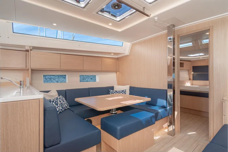 Slide: The Image of 2024 Bavaria C50 yacht interior with modern seating, wooden finishes, and skylights. - 48