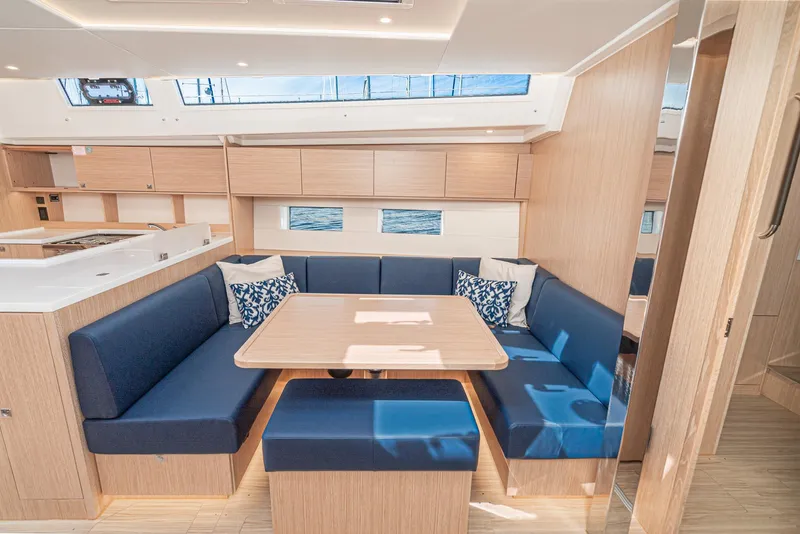 Slide: The Image of 2024 Bavaria C50 yacht interior with modern dining area and blue seating. - 49