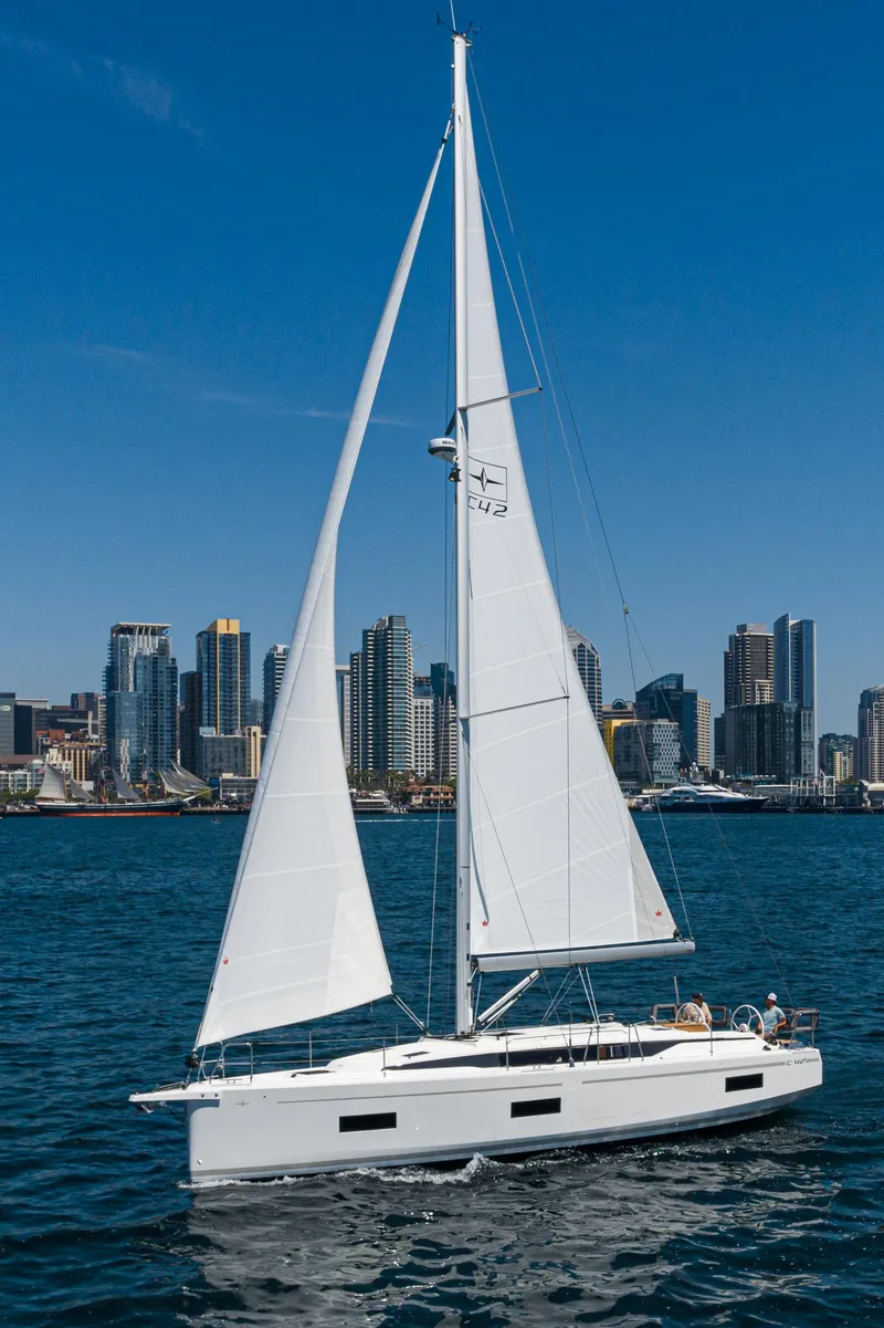 Slide: The Image of 2024 Bavaria C42 sailboat cruising near city skyline on a sunny day. - 1
