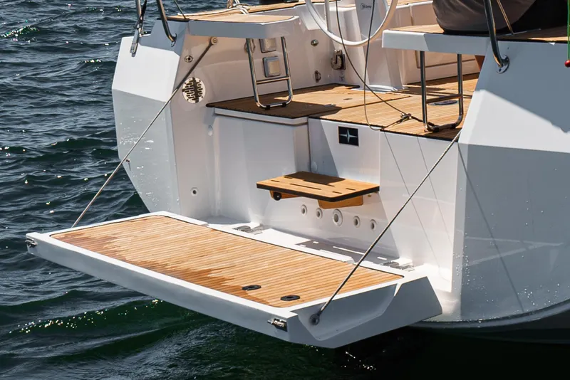 Slide: The Image of Bavaria C42 2024 yacht stern with teak swim platform on water. - 13