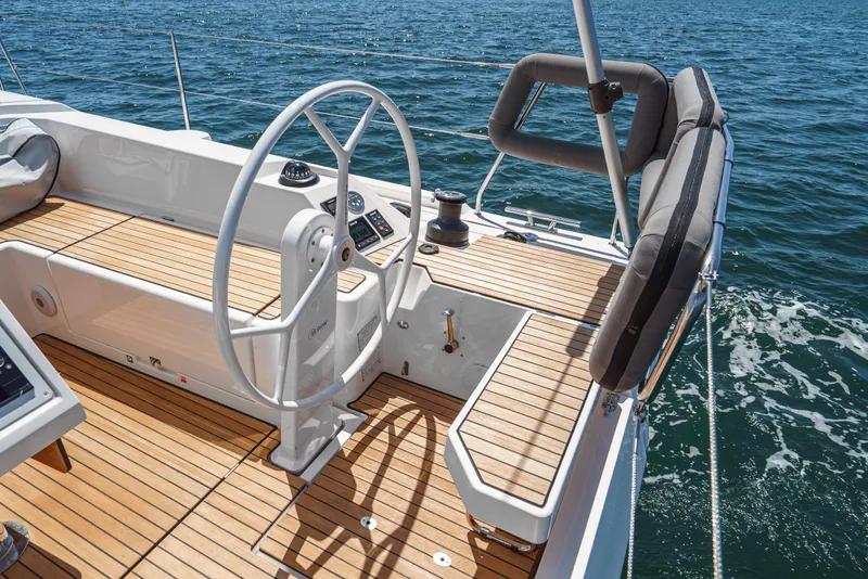 Slide: The Image of 2024 Bavaria C42 yacht helm with teak deck, steering wheel, and ocean view. - 15