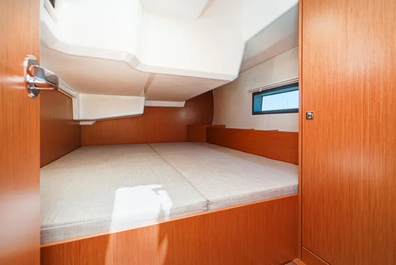 Slide: The Image of 2024 Bavaria C42 yacht cabin interior with wooden finish and comfortable bedding. - 41