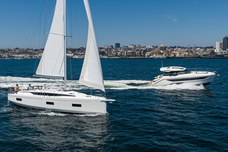Slide: The Image of 2024 Bavaria C42 sailboat and motorboat on a sunny day in a coastal city harbor. - 44