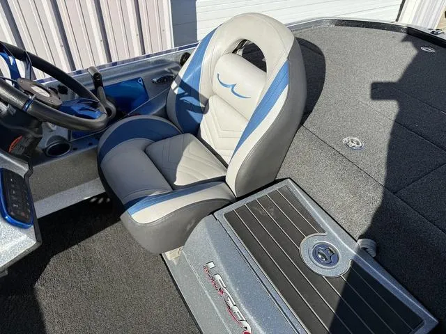 Slide: The Image of 2015 Legend V20 boat interior with gray and blue seating, steering wheel, and carpeted deck. - 17