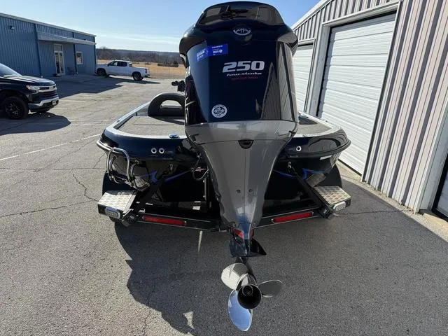 Slide: The Image of 2015 Legend V20 boat with 250 horsepower engine, parked near metal buildings. - 3